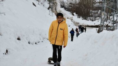 Şırnak’ta çocuklar, kullanılmayan yolları kayak pistine çevirip kızakla kaymanın tadını
