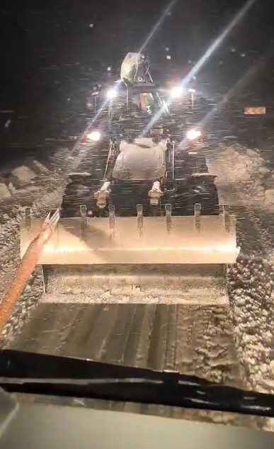 Diyarbakır’ın Dicle ilçesinde karlı yolda mahsur kalan tır, iş makinesiyle