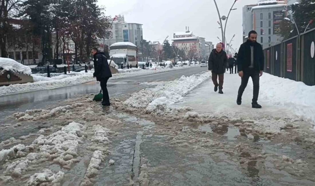 Muş’ta cadde ve kaldırımlarda biriken kar sularını kürekle temizleyen polisin