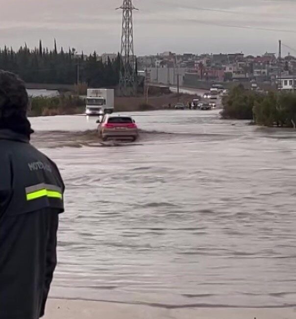 Adana’da şiddetli yağış sonucu oluşan su birikintisinden araçlar geçemezken bir
