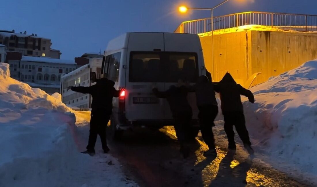 Hakkari’nin Yüksekova ilçesinde buzlanan yolda mahsur kalan bir minibüs, çevredeki