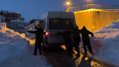 Hakkari’nin Yüksekova ilçesinde buzlanan yolda mahsur kalan bir minibüs, çevredeki