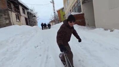 Tokat’ın Başçiftlik ilçesinde kar yağışının ardından snowboardla sokağa çıkan dayı-yeğen,