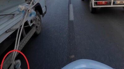Antalya’da iki kamyonet arasından geçmeye çalışan motokurye, sarkan branda ipine