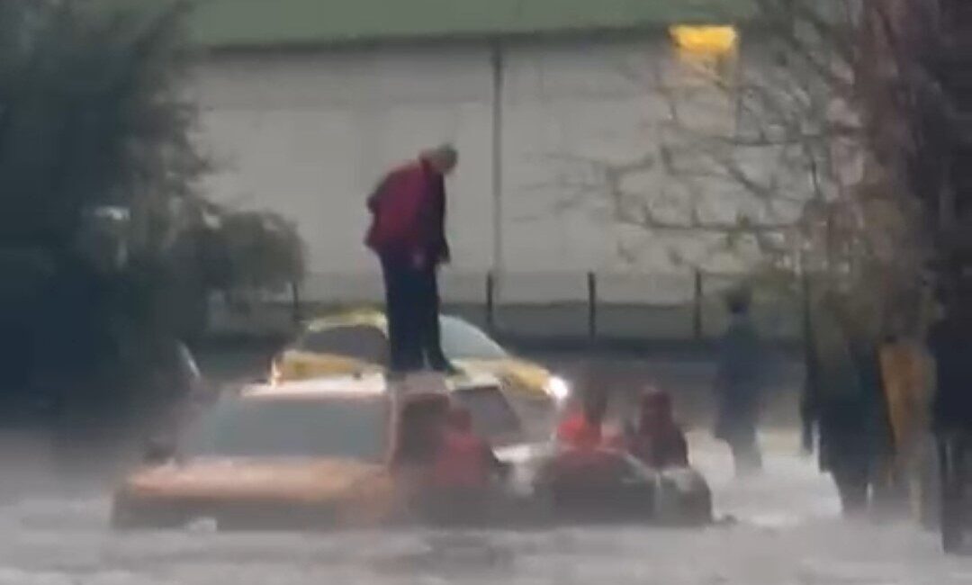 Adana’da dolu ve sağanak nedeniyle göle dönen yolda otomobilin üzerinde