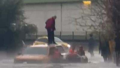 Adana’da dolu ve sağanak nedeniyle göle dönen yolda otomobilin üzerinde