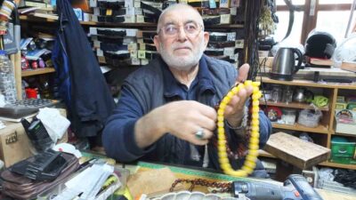 Burhaniye ilçesinde, 71 yaşındaki Cevat Büke tespih dizerek para kazanıyor.