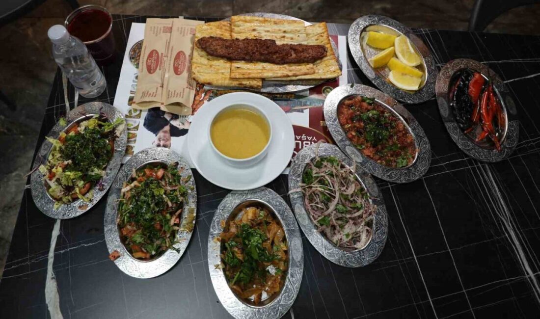 Tescilli Adana kebabı ve yanında servis edilen bol yeşillikli salatalar,